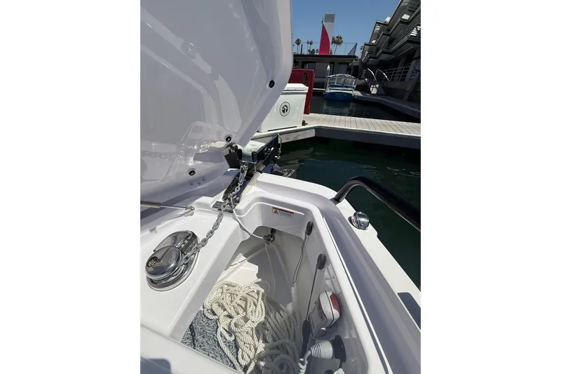 Slide: The Image of 2025 Axopar 29 XC Cross Cabin boat anchor compartment with ropes and chain at marina. - 6