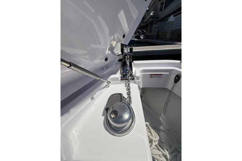 Slide: The Image of Anchor compartment of 2025 Axopar 29 XC Cross Cabin boat, featuring chain and winch. - 7