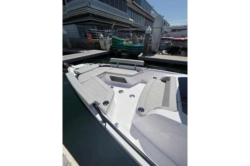 Slide: The Image of 2025 Axopar 29 XC Cross Cabin boat with spacious seating at a marina dock. - 8