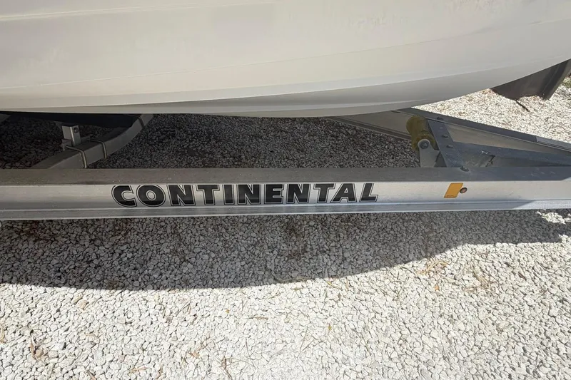 Slide: The Image of Continental boat trailer supporting a 2012 Pathfinder 2200 T on gravel surface. - 13
