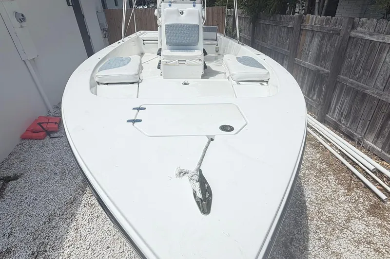 Slide: The Image of 2012 Pathfinder 2200 T boat docked on gravel beside a wooden fence. - 3