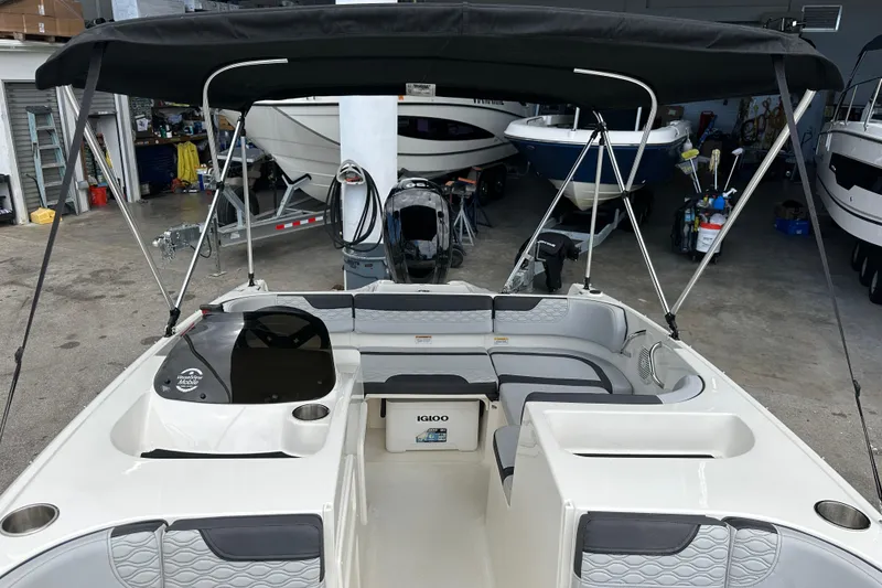 Slide: The Image of 2023 Bayliner M17 boat interior with seating and canopy in a showroom. - 11