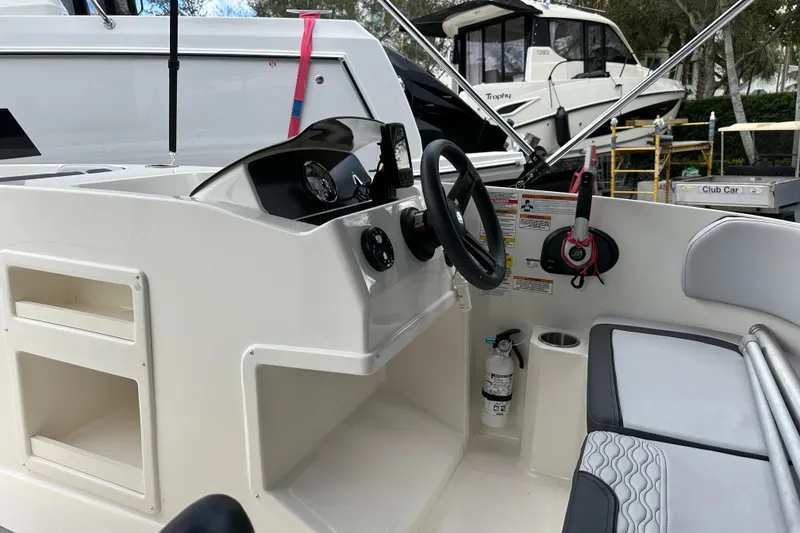 Slide: The Image of 2023 Bayliner M17 boat interior with steering wheel and seating area. - 13