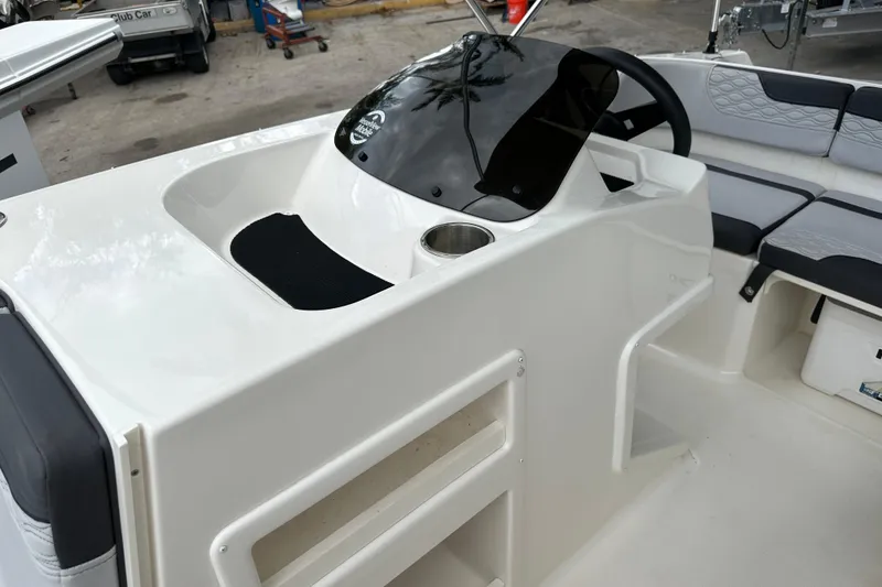 Slide: The Image of 2023 Bayliner M17 boat interior with steering console and seating area. - 19