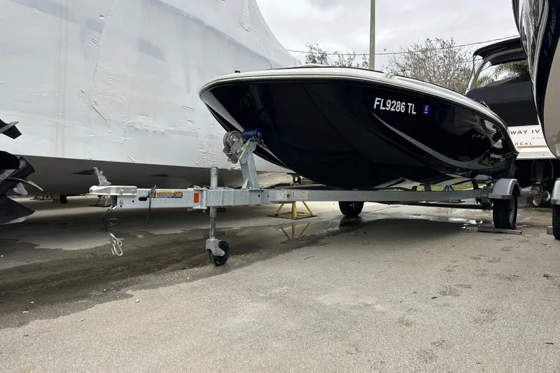 Slide: The Image of 2023 Bayliner Element M17 boat on trailer, parked outdoors. - 2