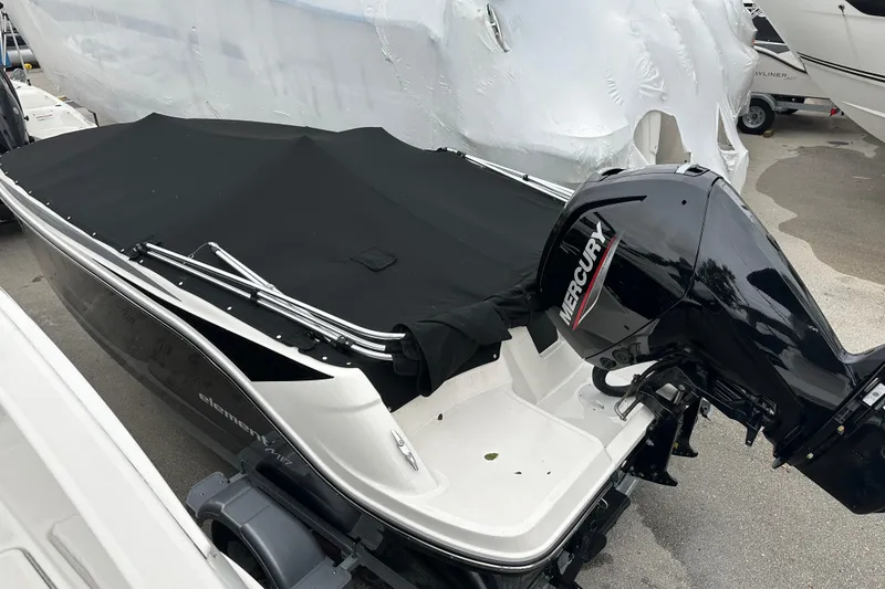 Slide: The Image of 2023 Bayliner Element M17 boat with Mercury outboard motor, covered and parked. - 25