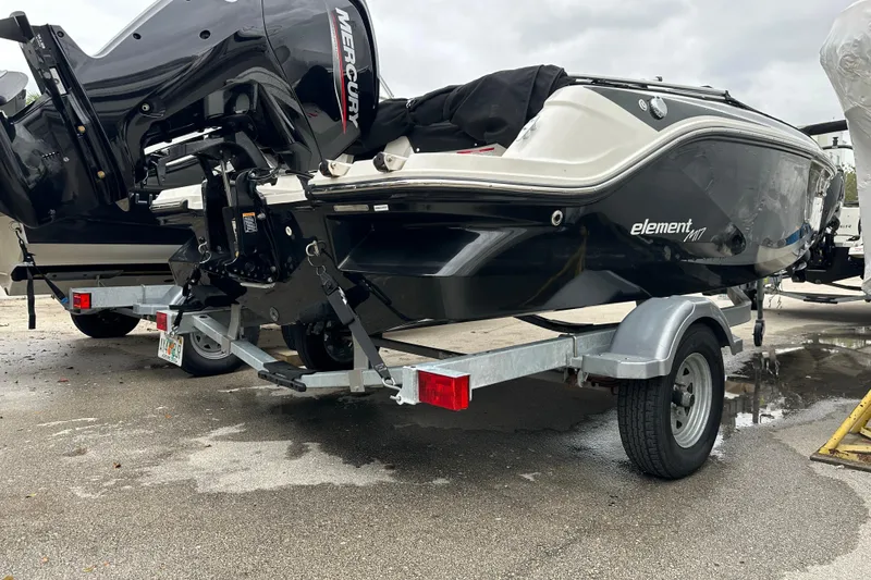 Slide: The Image of 2023 Bayliner Element M17 boat on trailer, featuring a Mercury outboard motor. - 7