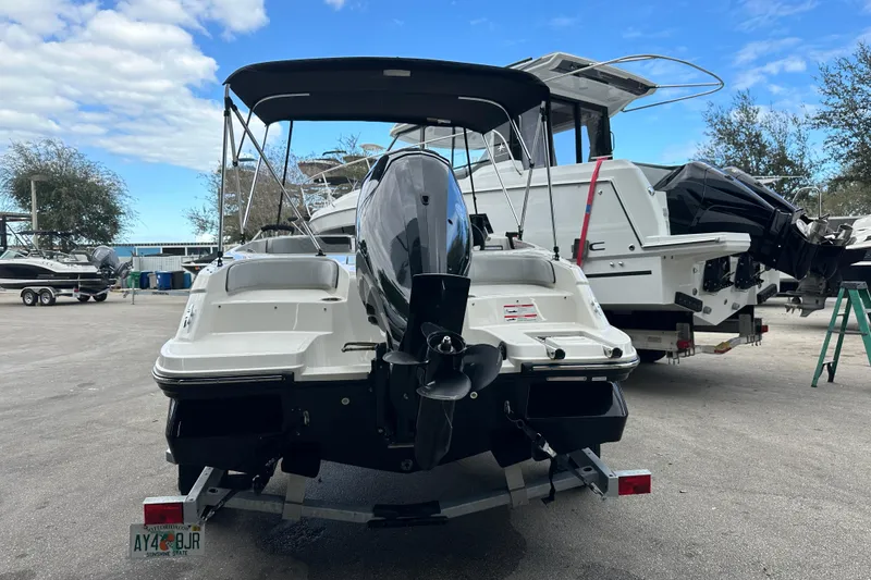 Slide: The Image of 2023 Bayliner M17 boat on trailer, parked outdoors under a blue sky. - 8