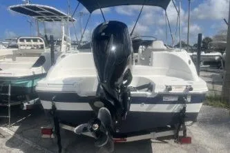 Slide: The Image of 2022 Hurricane SunDeck Sport 192 RL OB boat with outboard motor, docked under blue sky. - 4