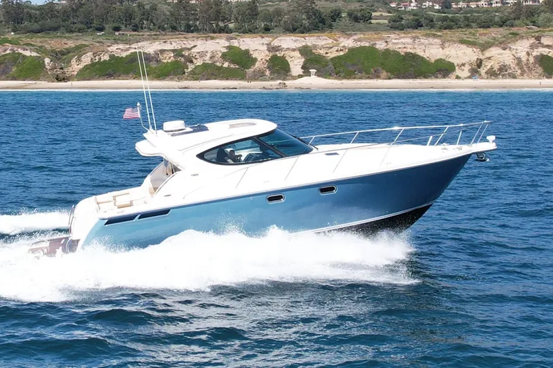 The Image of 2012 Tiara Yachts 4500 Sovran cruising on blue ocean near scenic coastline. - 0