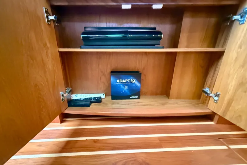 Slide: The Image of Wooden cabinet interior on a 2012 Tiara Yachts 4500 Sovran, featuring electronics and a Bose ADAPTiQ box. - 17