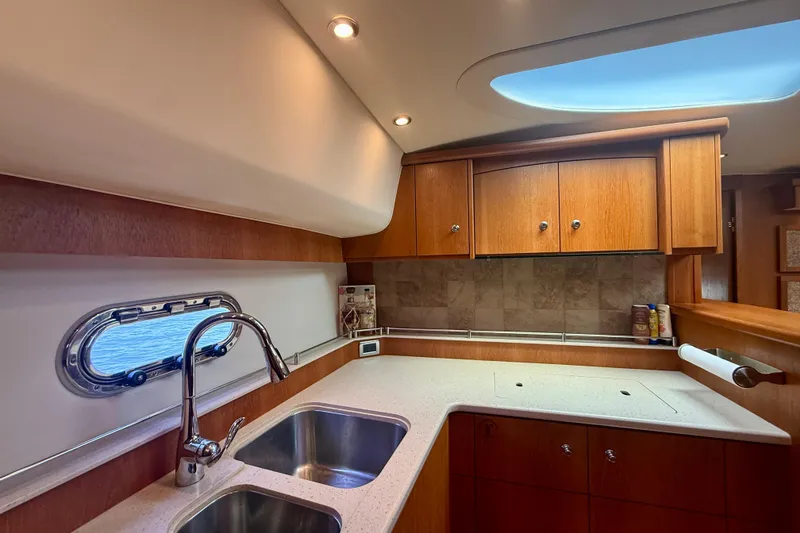 Slide: The Image of Luxurious 2012 Tiara Yachts 4500 Sovran kitchen with wood cabinetry and stainless steel sink. - 24