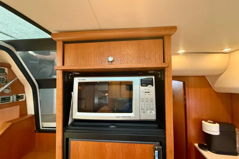 Slide: The Image of Interior of 2012 Tiara Yachts 4500 Sovran featuring a microwave and wooden cabinetry. - 27