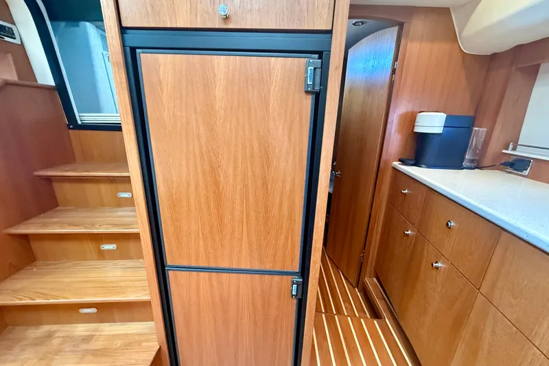 Slide: The Image of Interior of 2012 Tiara Yachts 4500 Sovran, featuring wooden cabinetry and stairs. - 28