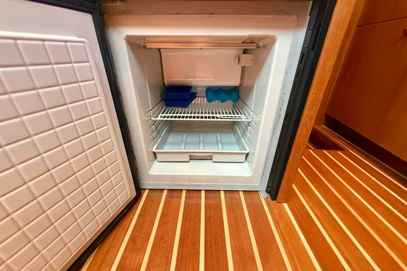 Slide: The Image of Open refrigerator in 2012 Tiara Yachts 4500 Sovran, showcasing interior storage and wooden flooring. - 31