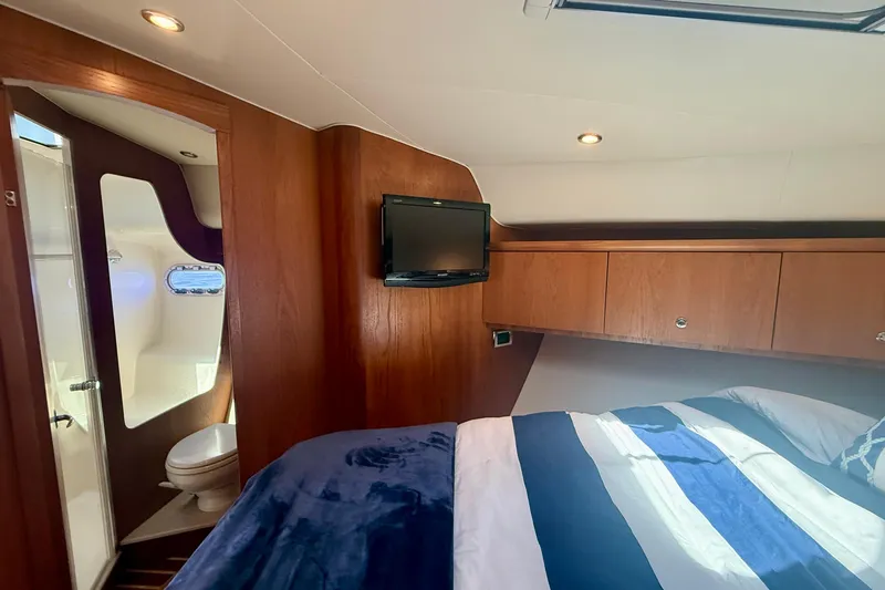Slide: The Image of Luxurious 2012 Tiara Yachts 4500 Sovran cabin with bed, TV, and ensuite bathroom. - 33