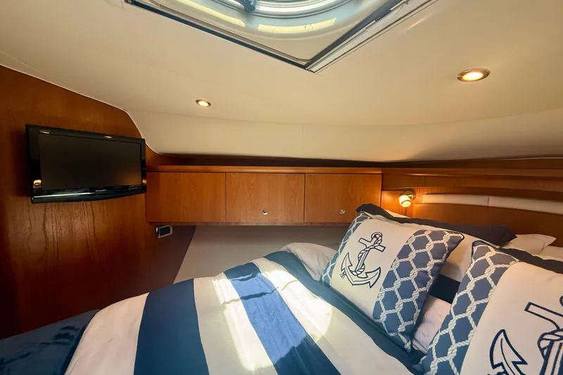 Slide: The Image of Luxurious cabin interior of 2012 Tiara Yachts 4500 Sovran with nautical-themed bedding. - 34