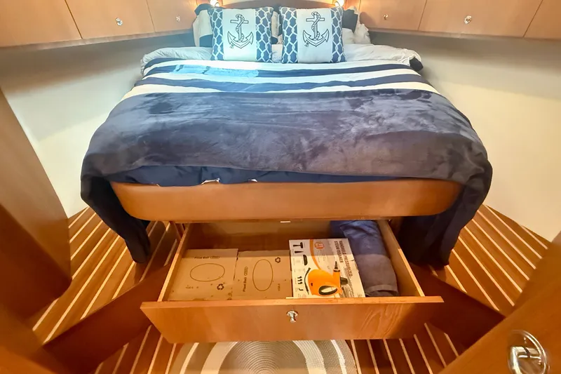 Slide: The Image of Cozy bedroom in 2012 Tiara Yachts 4500 Sovran with nautical-themed decor and storage drawer. - 36