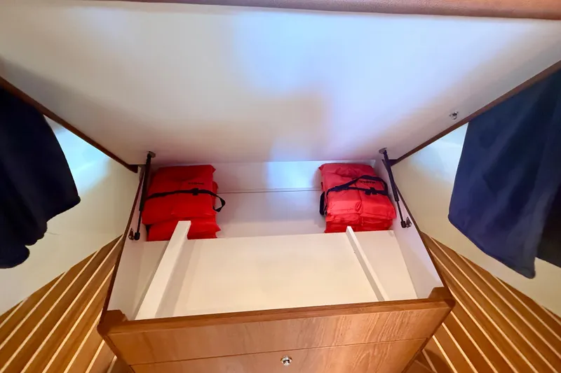Slide: The Image of Storage compartment with red life jackets on a 2012 Tiara Yachts 4500 Sovran. - 37