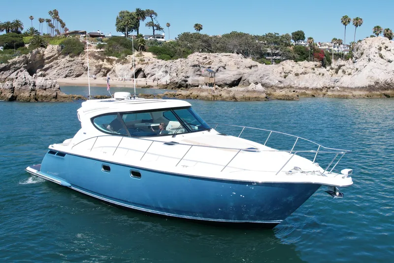 Slide: The Image of 2012 Tiara Yachts 4500 Sovran cruising near rocky coastline. - 4