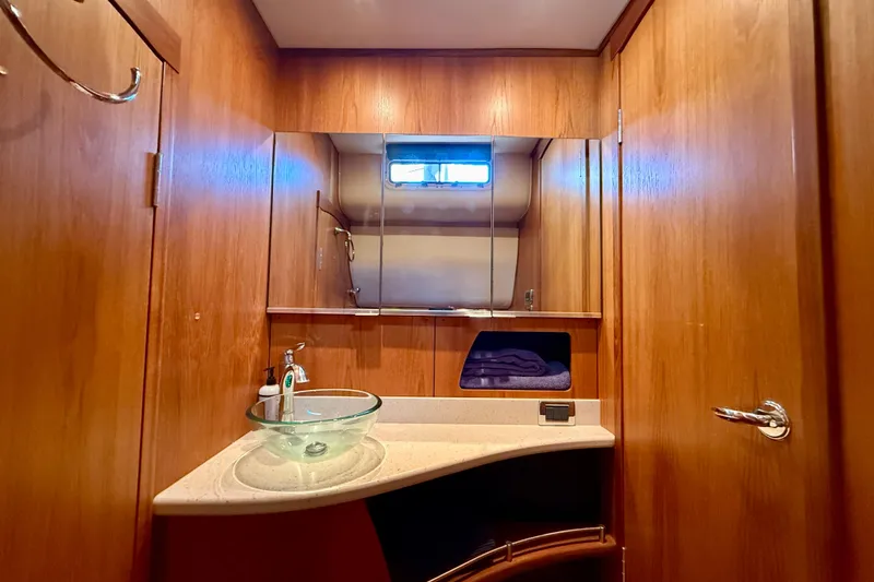 Slide: The Image of Luxurious bathroom in 2012 Tiara Yachts 4500 Sovran with glass sink and wooden cabinetry. - 43
