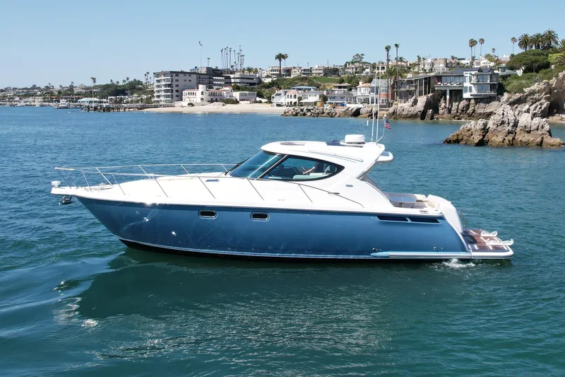 Slide: The Image of 2012 Tiara Yachts 4500 Sovran cruising near scenic coastal homes. - 5