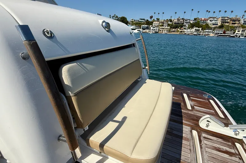 Slide: The Image of 2012 Tiara Yachts 4500 Sovran with beige seating, docked by waterfront homes. - 71