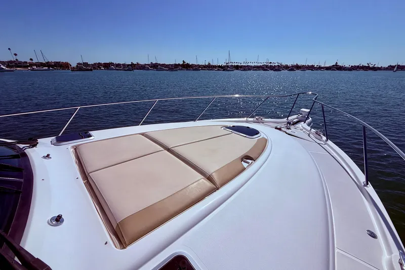 Slide: The Image of 2012 Tiara Yachts 4500 Sovran bow with sunpad, overlooking calm waters and distant shoreline. - 72