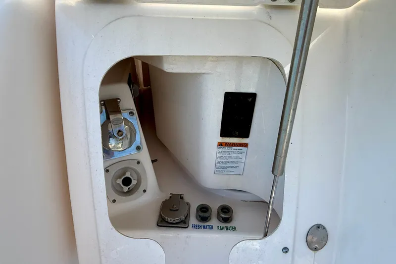 Slide: The Image of Access panel on a 2012 Tiara Yachts 4500 Sovran, showing water connections and warning label. - 75