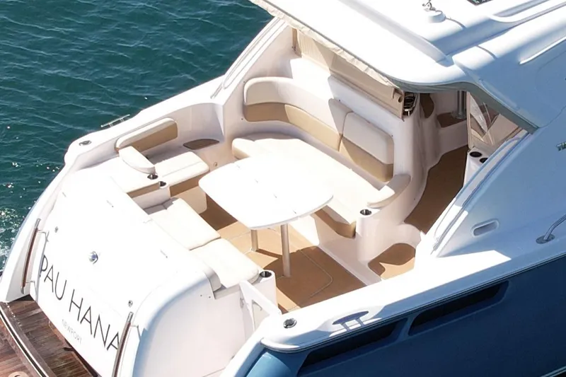 Slide: The Image of 2012 Tiara Yachts 4500 Sovran with spacious deck seating and table, docked on calm water. - 9