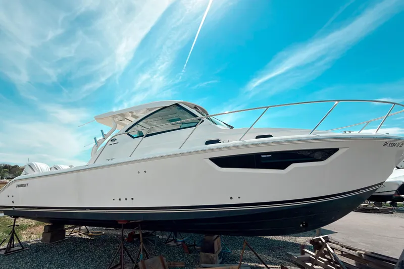 The Image of 2025 Pursuit OS 325 Offshore boat displayed under a vibrant blue sky. - 0