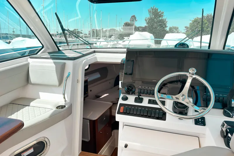 Slide: The Image of 2025 Pursuit OS 325 Offshore boat cockpit with modern controls and steering wheel. - 12