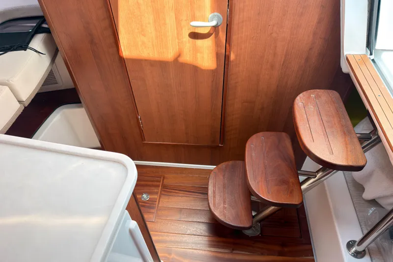 Slide: The Image of Interior of 2025 Pursuit OS 325 Offshore boat with wooden steps and door. - 14