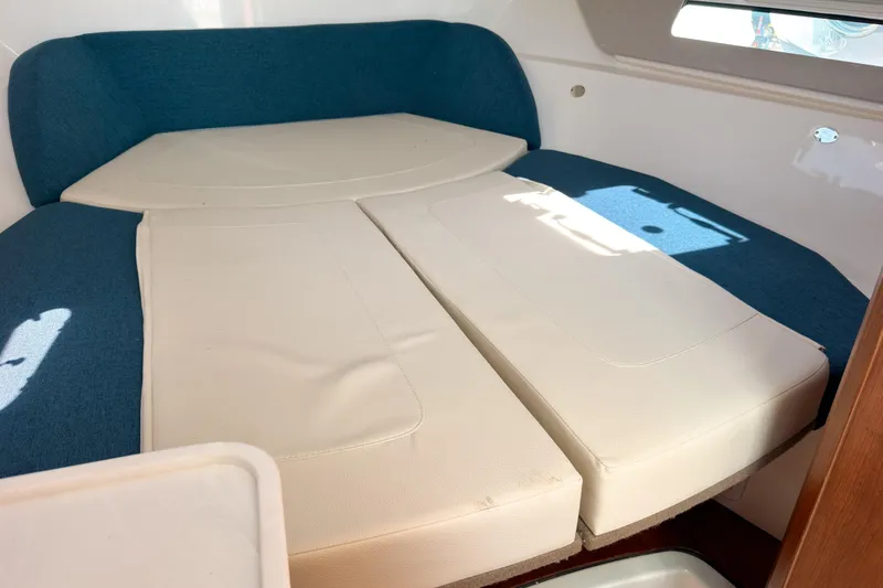 Slide: The Image of 2025 Pursuit OS 325 Offshore cabin interior with blue and white seating. - 15
