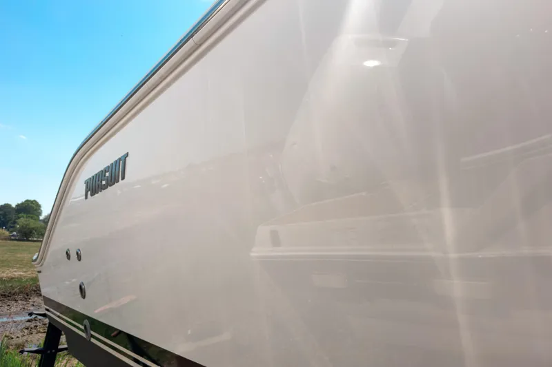 Slide: The Image of 2025 Pursuit OS 325 Offshore boat side view under clear blue sky. - 2