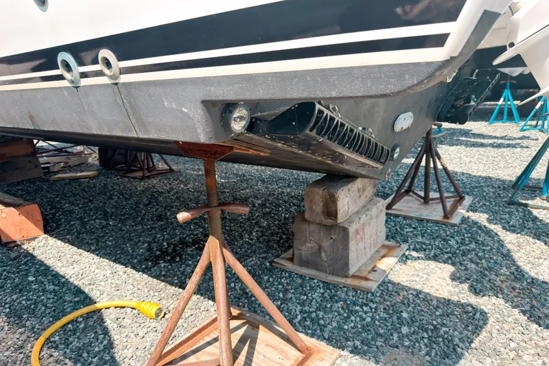 Slide: The Image of 2025 Pursuit OS 325 Offshore boat hull on stands, showcasing underside details. - 4