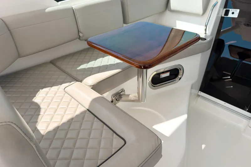 Slide: The Image of Luxurious seating area with a wooden table on the 2025 Pursuit OS 325 Offshore boat. - 8