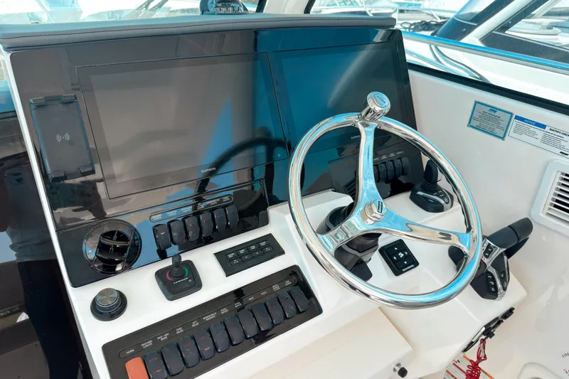 Slide: The Image of 2025 Pursuit OS 325 Offshore helm with dual screens and modern controls. - 9