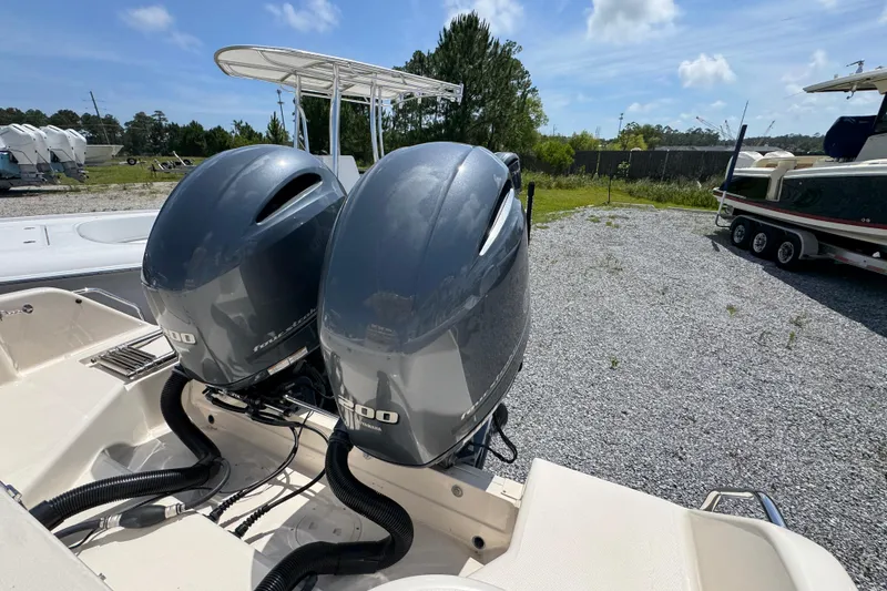Slide: The Image of Twin outboard engines on a 2022 Grady-White Fisherman 257 boat, parked on gravel. - 36