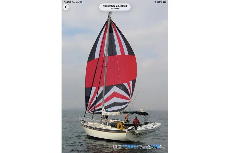 Slide: The Image of Sailboat on water with vibrant red and black sail, Gulf Pilot House 1989 model. - 0