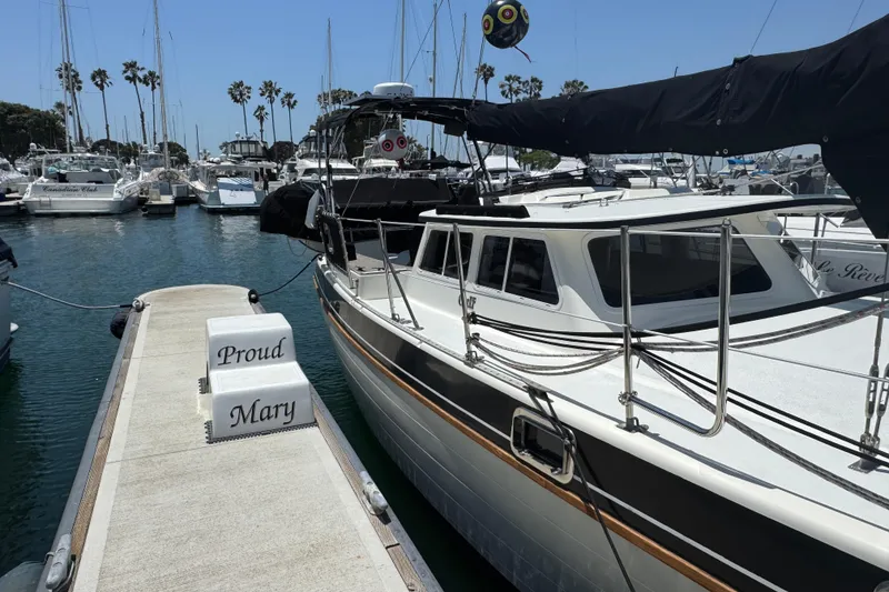Slide: The Image of 1989 Gulf Pilot House boat docked at marina, labeled "Proud Mary," surrounded by other vessels. - 12