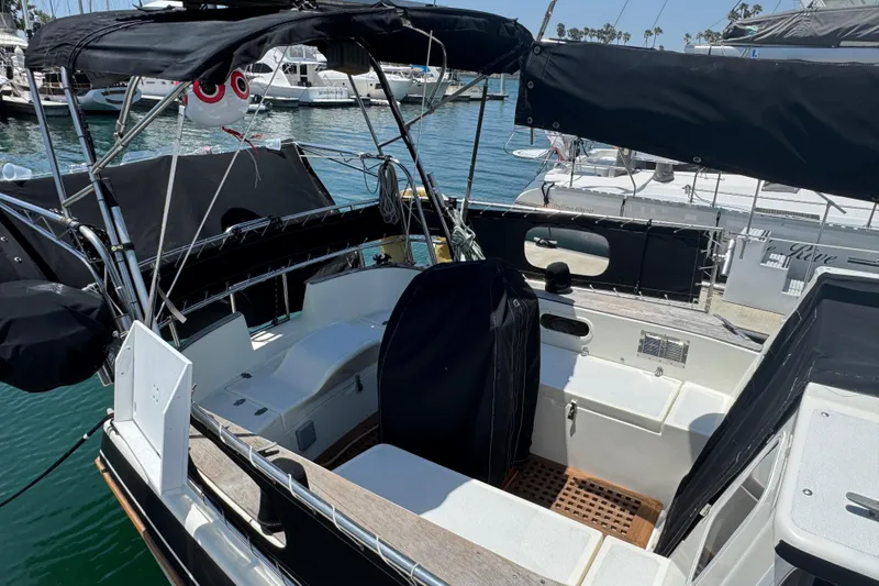 Slide: The Image of 1989 Gulf Pilot House boat docked in marina, featuring covered seating area and nautical equipment. - 14