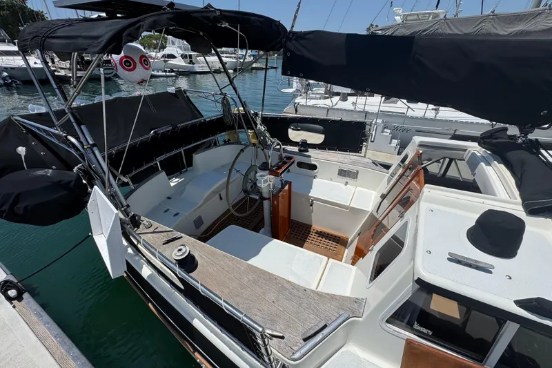 Slide: The Image of 1989 Gulf Pilot House sailboat cockpit with steering wheel, docked in marina. - 15