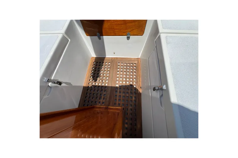 Slide: The Image of 1989 Gulf Pilot House boat interior with wooden flooring and storage compartments. - 19
