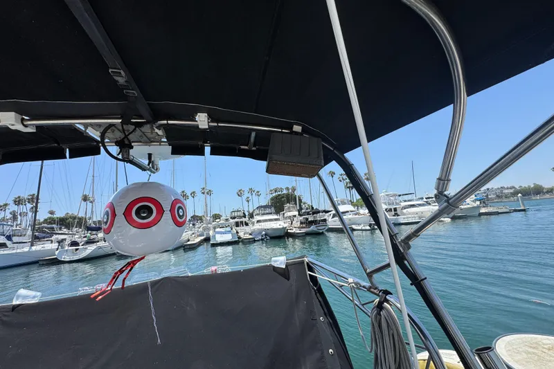 Slide: The Image of 1989 Gulf Pilot House boat in marina, featuring a decorative balloon and clear blue sky. - 23