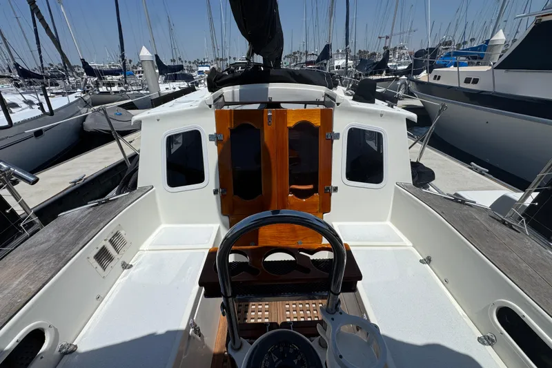 Slide: The Image of 1989 Gulf Pilot House yacht cockpit with wooden doors, docked among sailboats. - 25