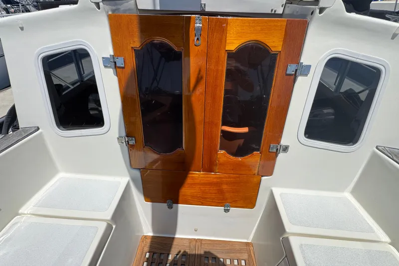 Slide: The Image of 1989 Gulf Pilot House boat cockpit with wooden doors and seating. - 26