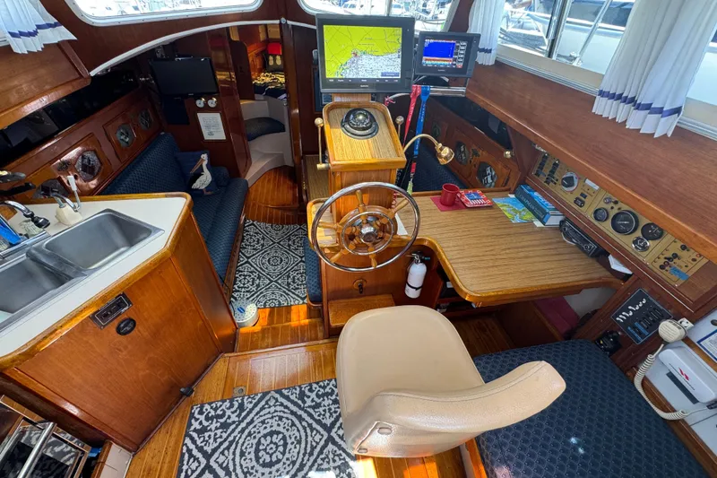 Slide: The Image of Interior of a 1989 Gulf Pilot House boat with helm, navigation equipment, and cozy seating. - 28