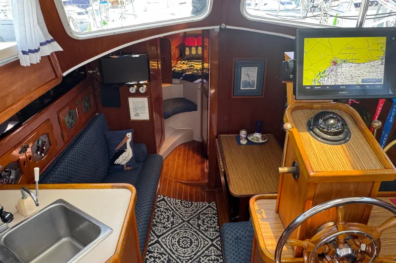 Slide: The Image of Interior of a 1989 Gulf Pilot House boat with navigation equipment and cozy seating area. - 29