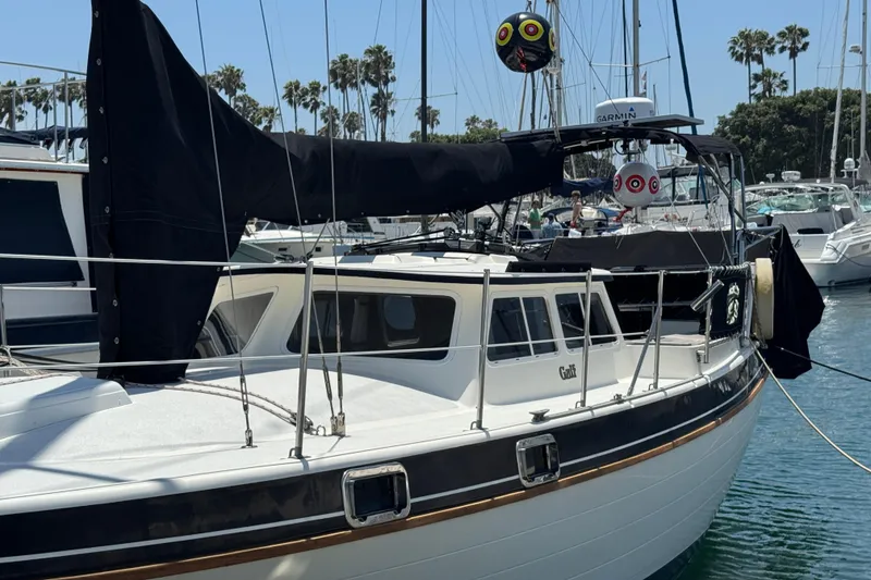 Slide: The Image of 1989 Gulf Pilot House sailboat docked in a marina with palm trees in the background. - 3